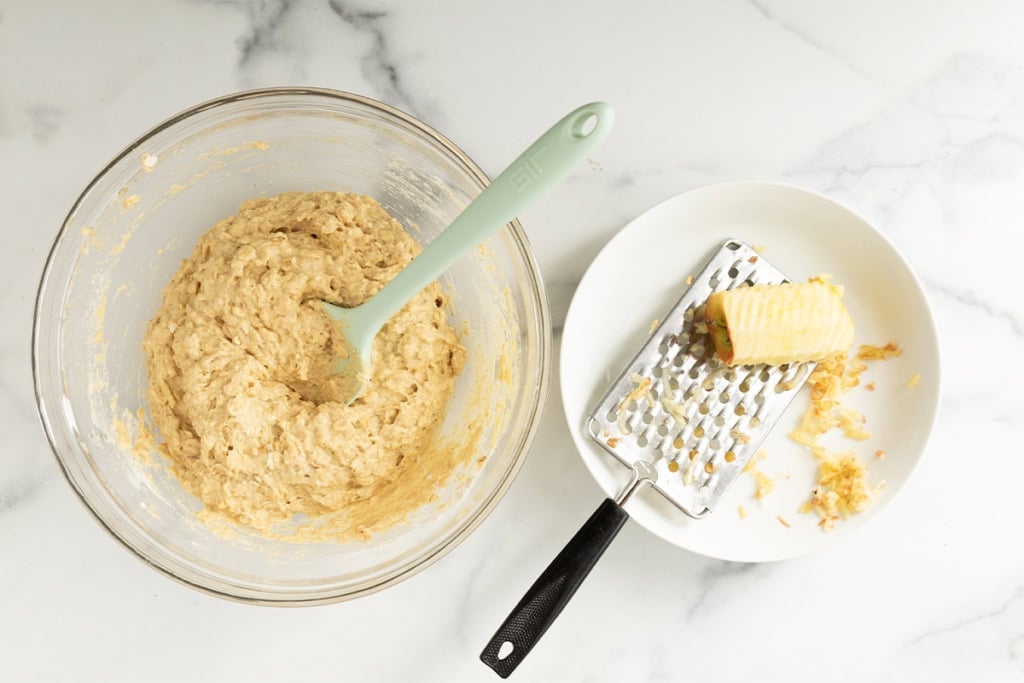 Shredding apple into batter for apple oatmeal pancakes.