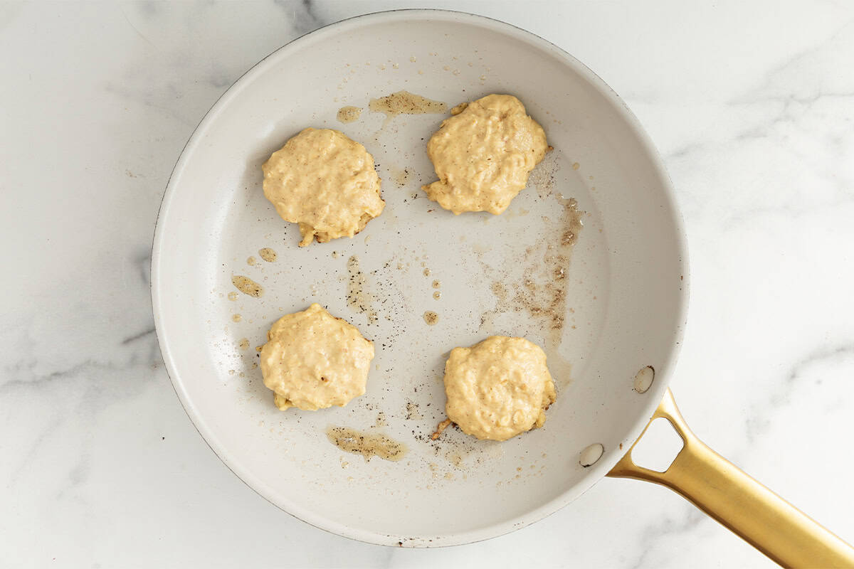 Apple oatmeal pancakes in pan before flipping.