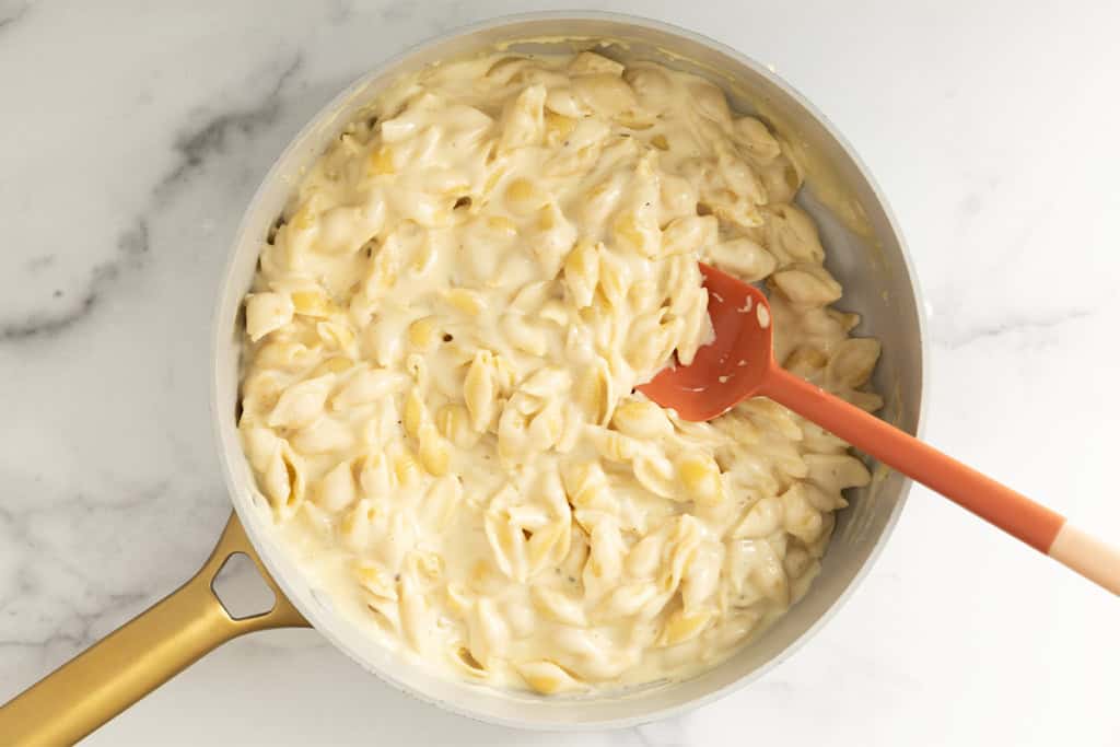 Simple mac and cheese in pan with spoon.
