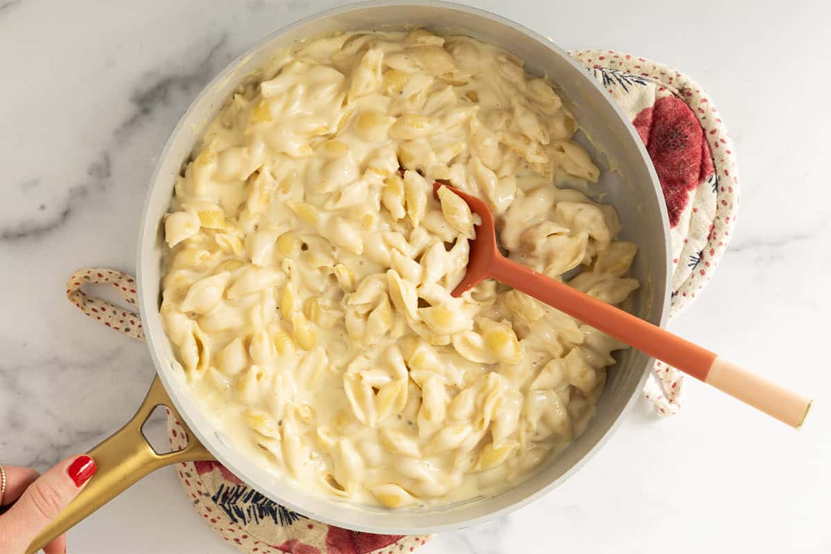 Simple mac and cheese in pan with spoon.