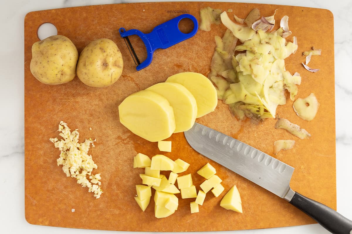 Chopping vegetables on cutting board for vegetable soup.