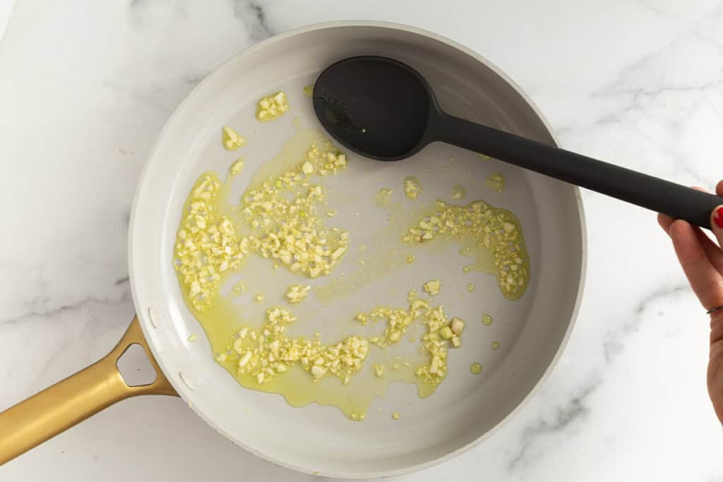 Sautéing garlic in pan for vegetable soup.
