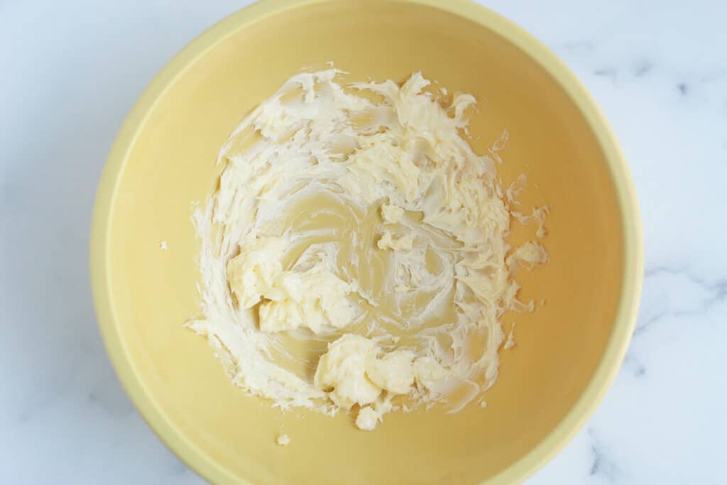 beaten butter in yellow bowl.