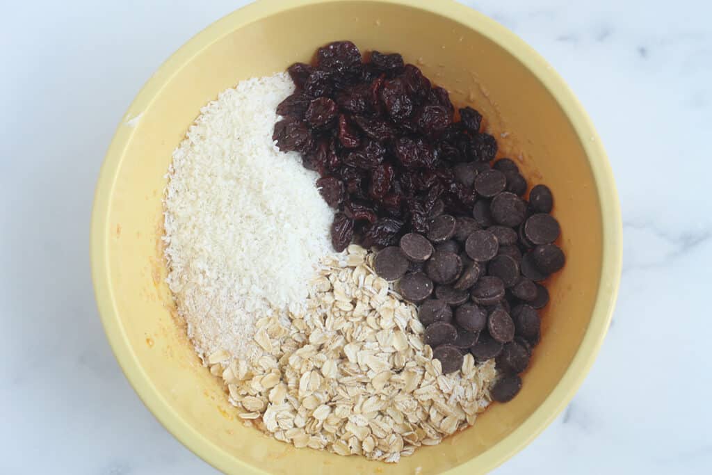 dry ingredients for healthy oatmeal chocolate chip cookies in yellow bowl.