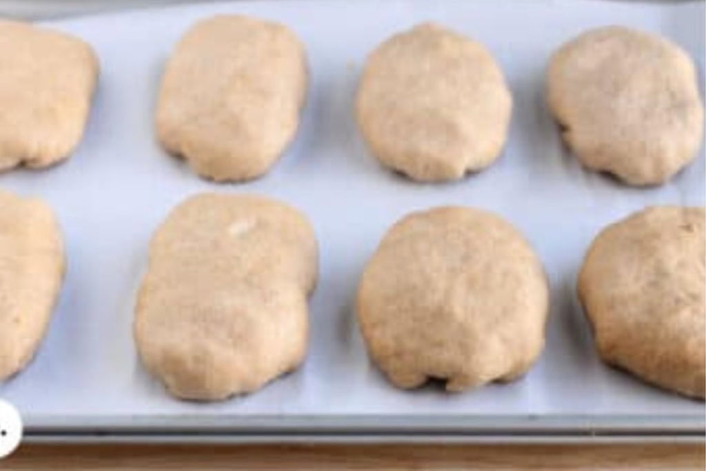 Cheesy meat buns on pan before baking.