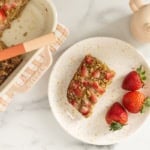 Baked oatmeal bar on plate with strawberries.