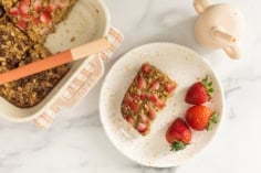 Baked oatmeal bar on plate with strawberries.