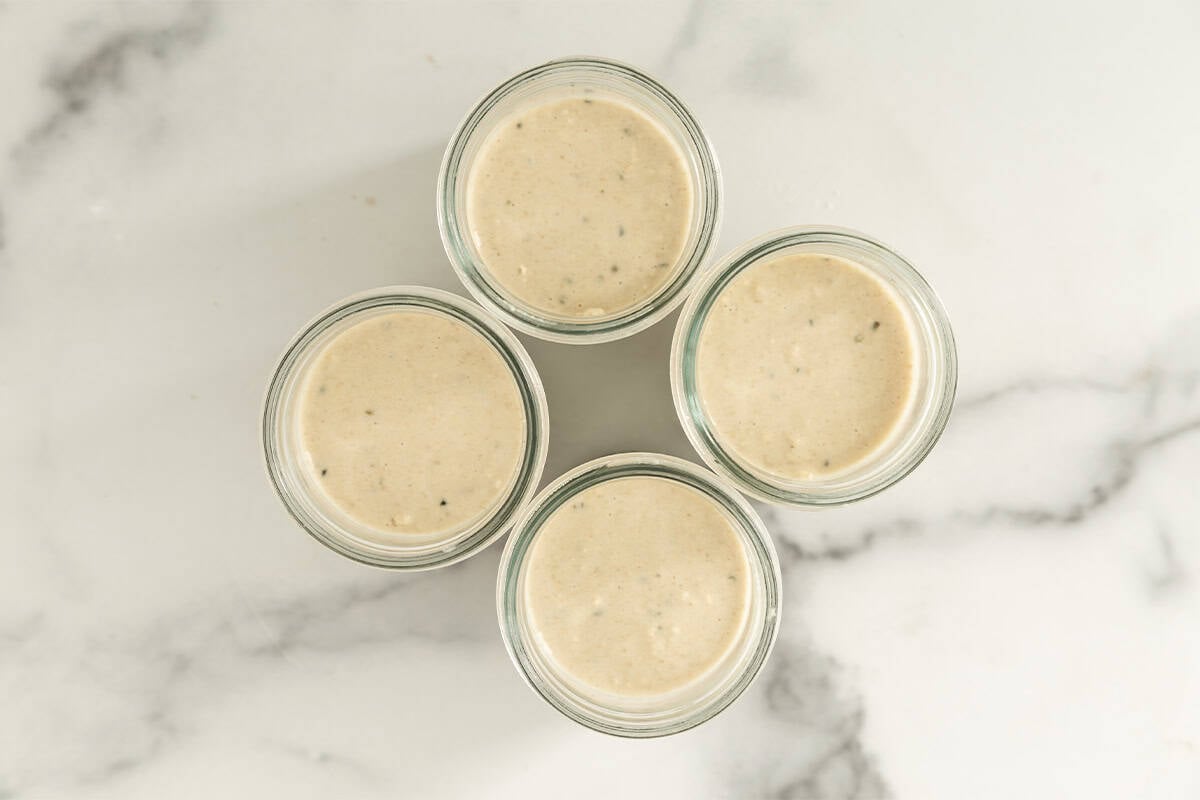 Coconut overnight oats in four glass jars.