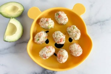 salmon rice balls on plate with avocado.