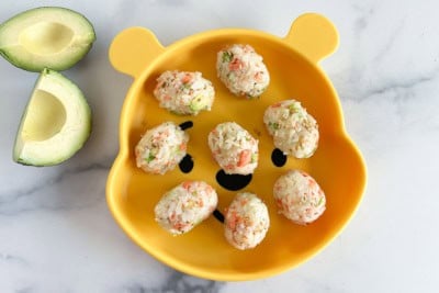 salmon rice balls on plate with avocado.
