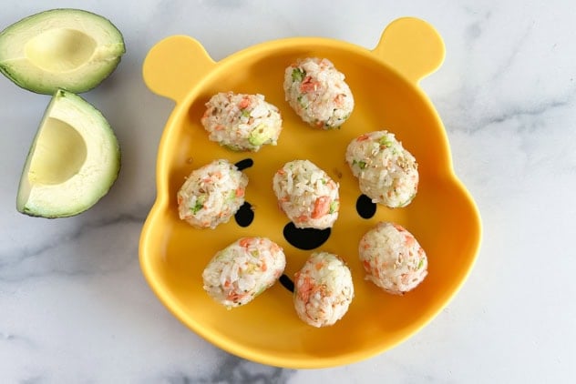 salmon rice balls on plate with avocado.