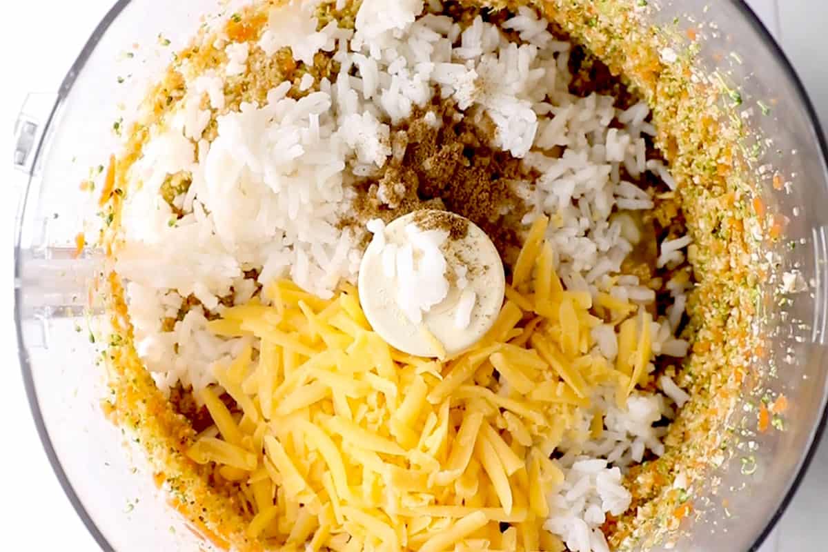 Adding ingredients to veggies in food processor for veggie nuggets.