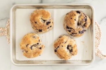 Blueberry Bagels on baking sheet after baking.