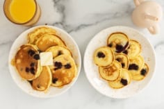 Blueberry protein pancakes on two plates.