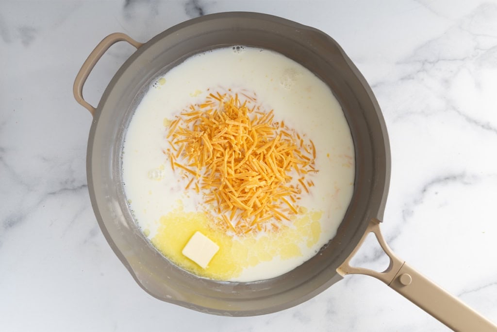 Cheese, milk and butter in sauce pan for broccoli cheddar pasta.