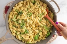 Broccoli cheddar pasta in pot with spoon.