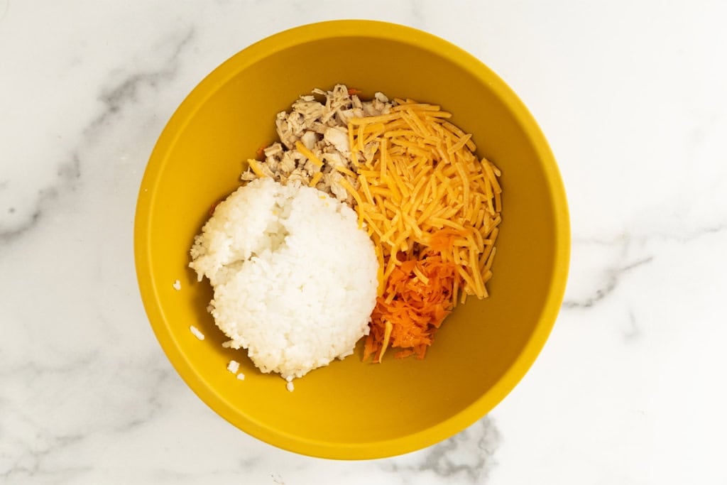 Ingredients for chicken and rice balls in yellow bowl.
