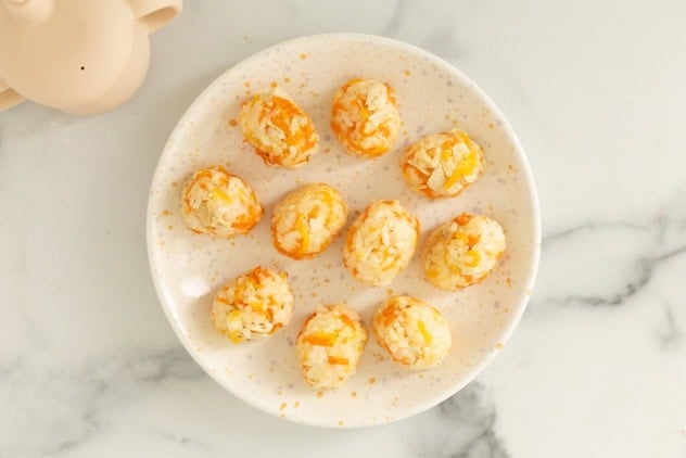 Chicken and rice balls on white plate.