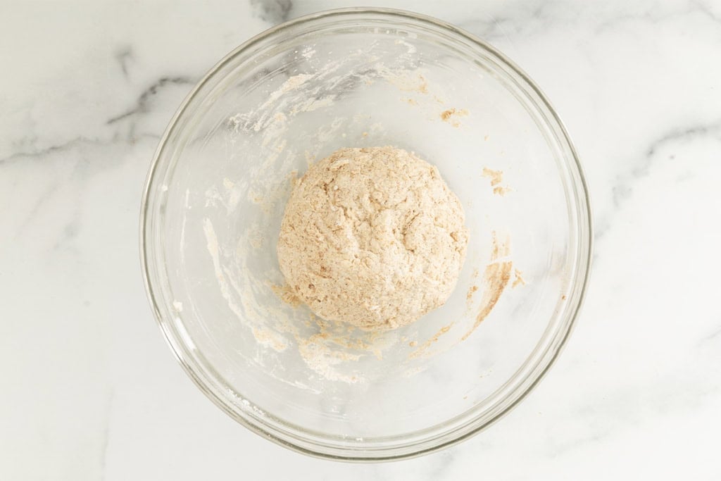 Dough for cinnamon bagels in glass bowl before adding raisins.