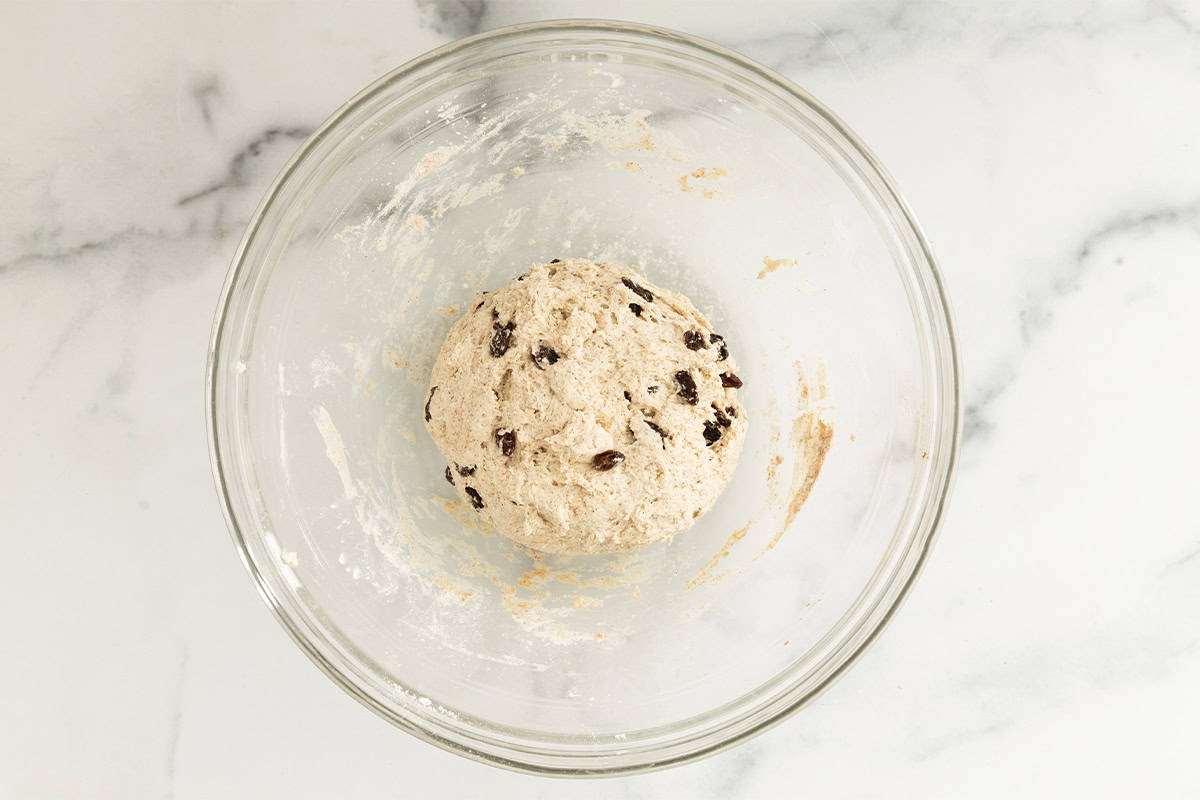 Cinnamon raisin bagel dough in glass bowl.