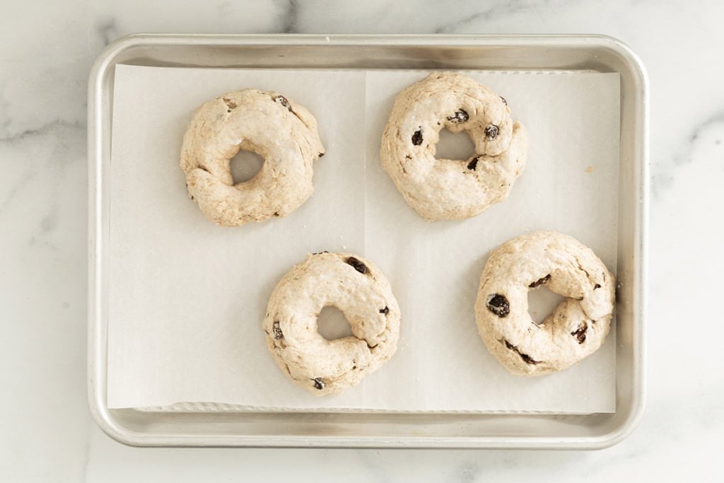 Cinnamon raisin bagels on baking sheet before baking.