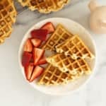 Cottage cheese waffle on white plate with strawberries.