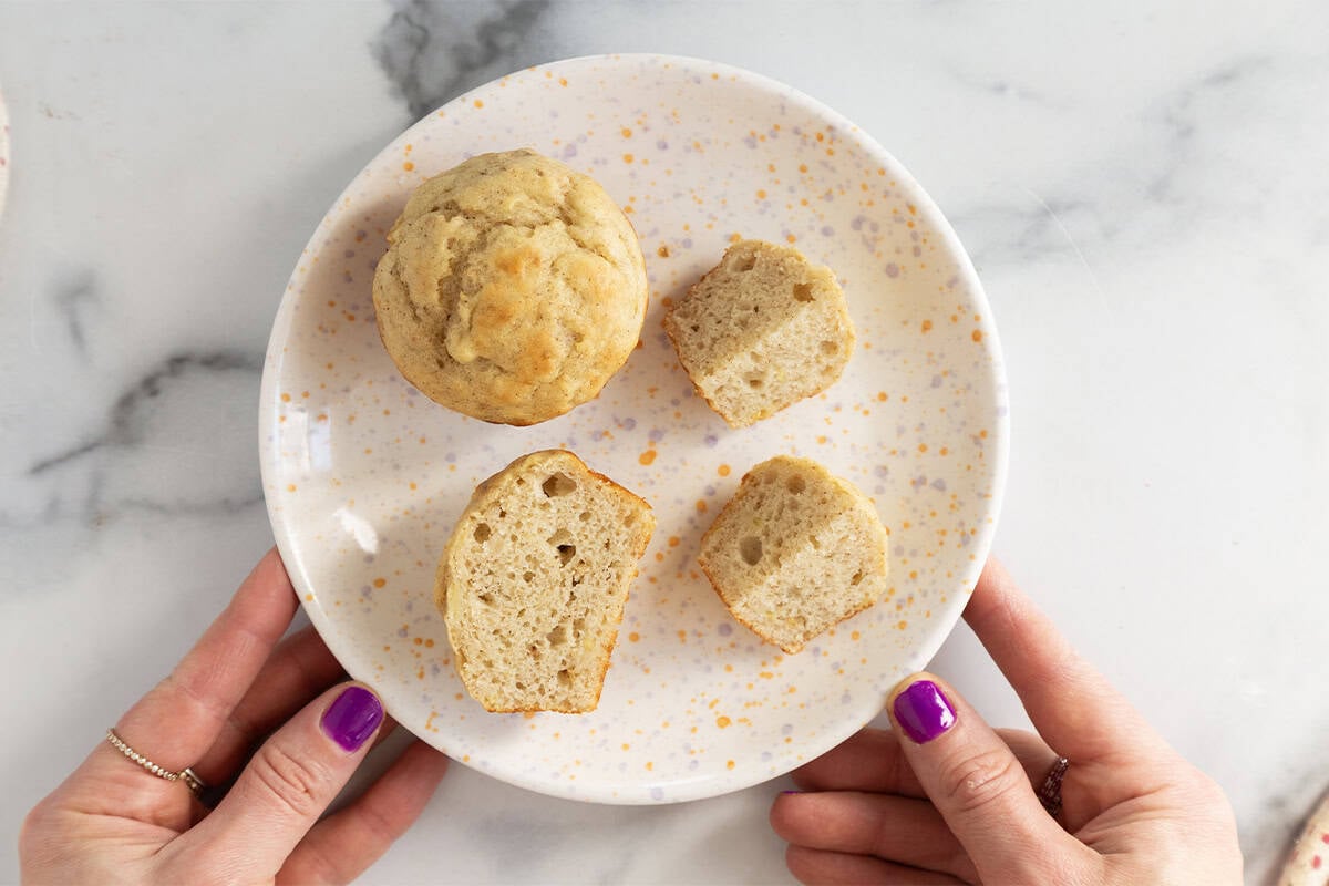 Greek yogurt banana muffins cut up on white plate.