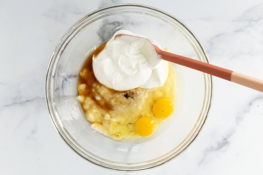 Ingredients for greek yogurt banana muffins in glass bowl.