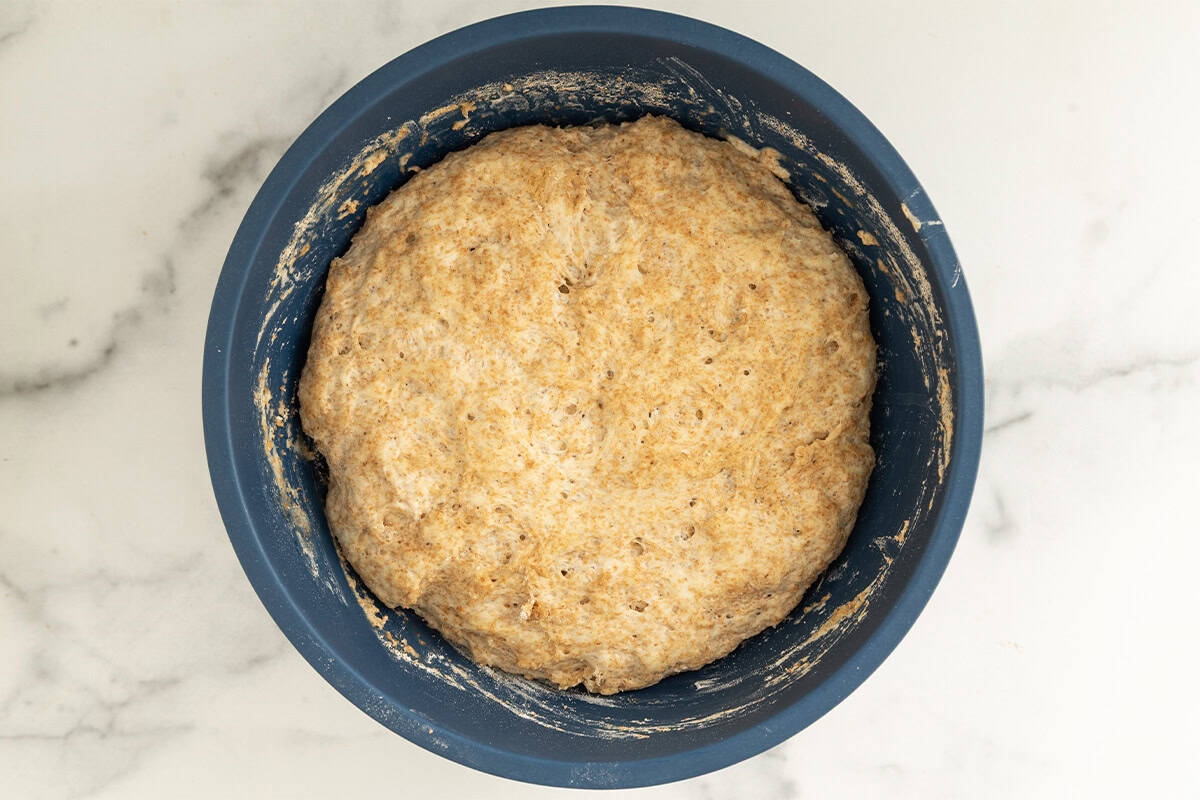 no knead pizza dough in blue bowl.