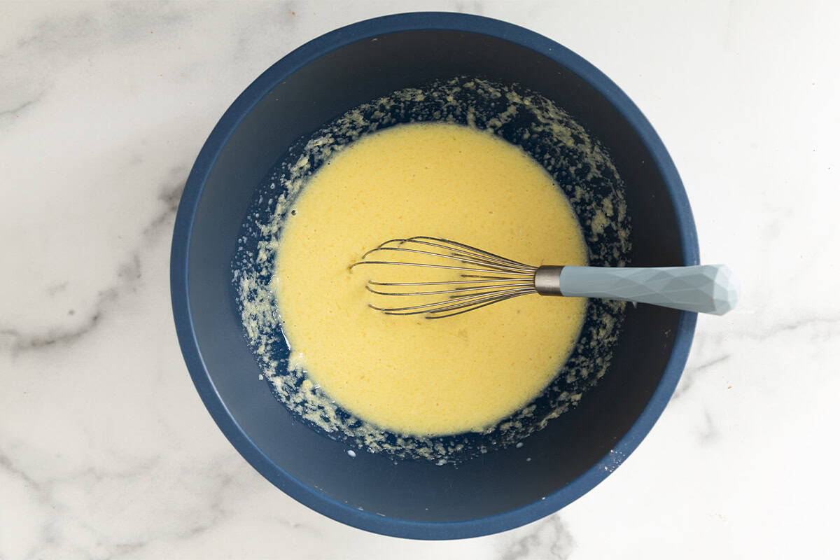 Wet ingredients for blueberry oatmeal muffins in blue bowl.