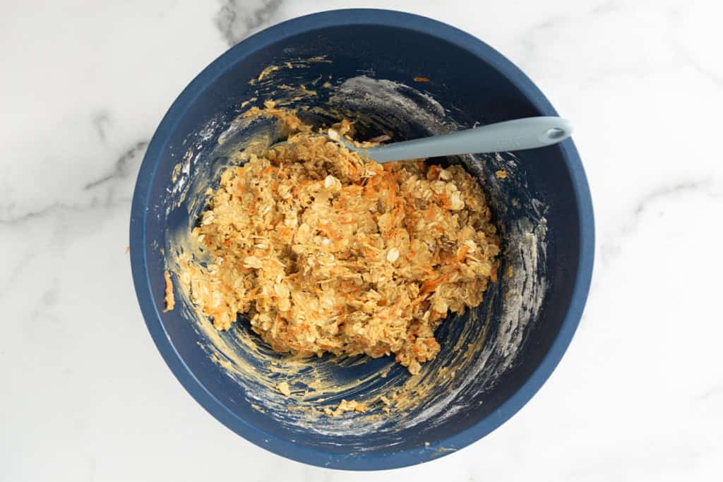 Batter for carrot oatmeal cookies in blue bowl.