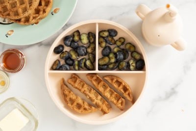 Chocolate waffles on kids plate with blueberries.