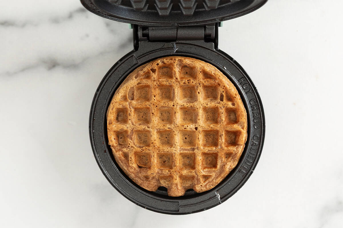 Chocolate waffle in waffle iron.