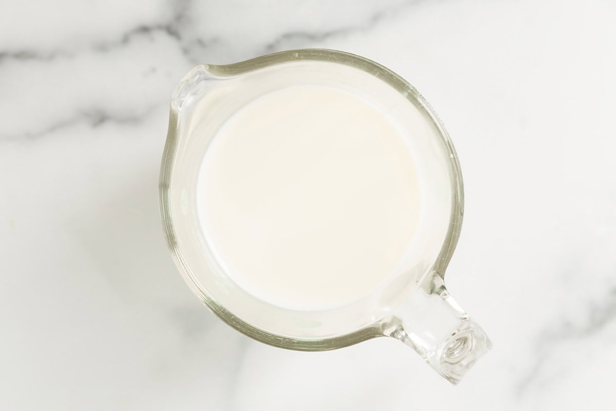 Milk in measuring cup for pancakes without eggs.