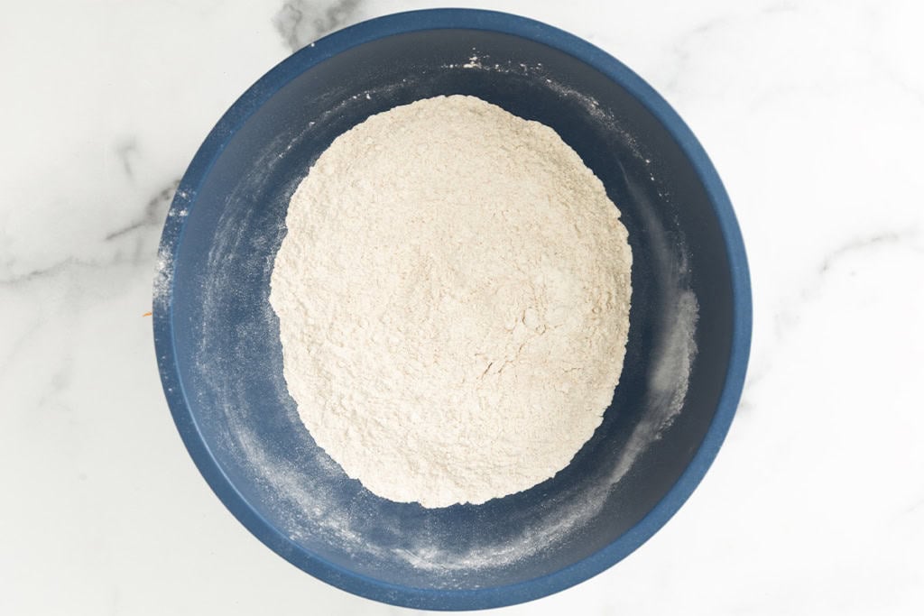 Dry ingredients for pancakes without eggs in blue bowl.