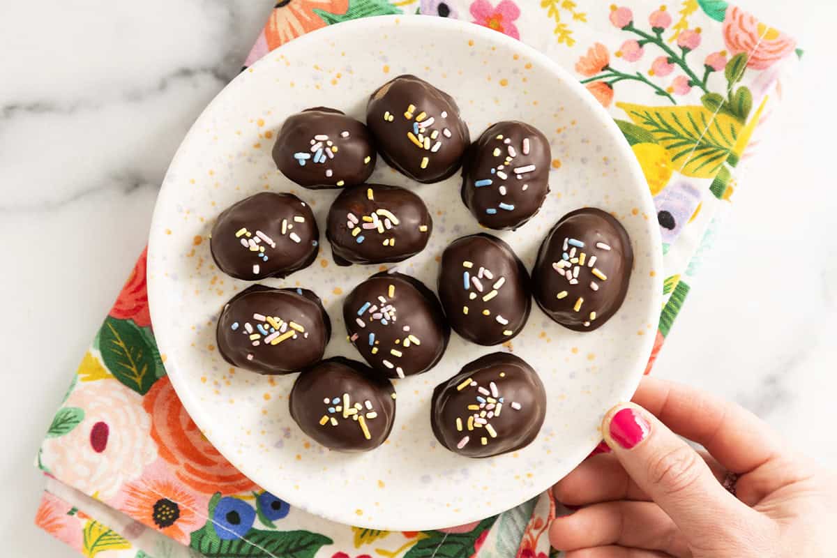 Peanut butter eggs on white plate.