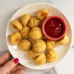 Quinoa bites on white plate with ketchup.