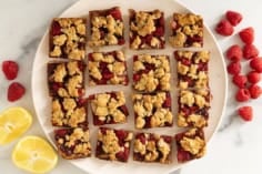 Raspberry oatmeal bars on white plate.