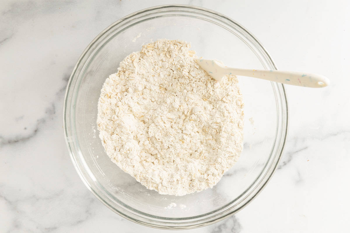 Dry ingredients in glass bowl for raspberry oatmeal bars.