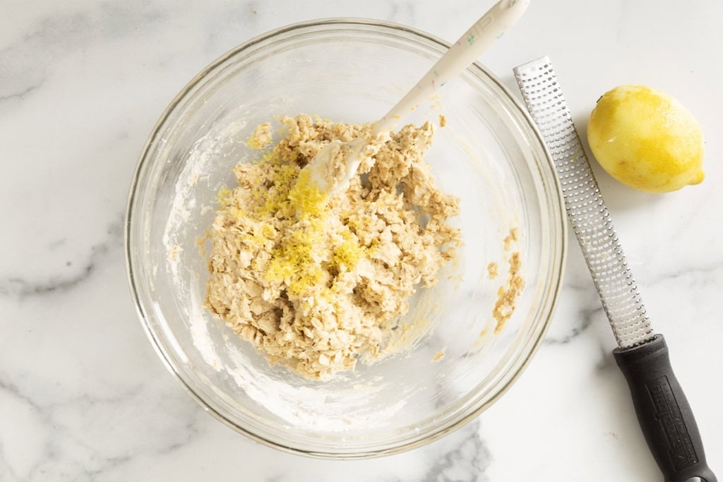 Batter for raspberry oatmeal bars in glass bowl with lemon zest.