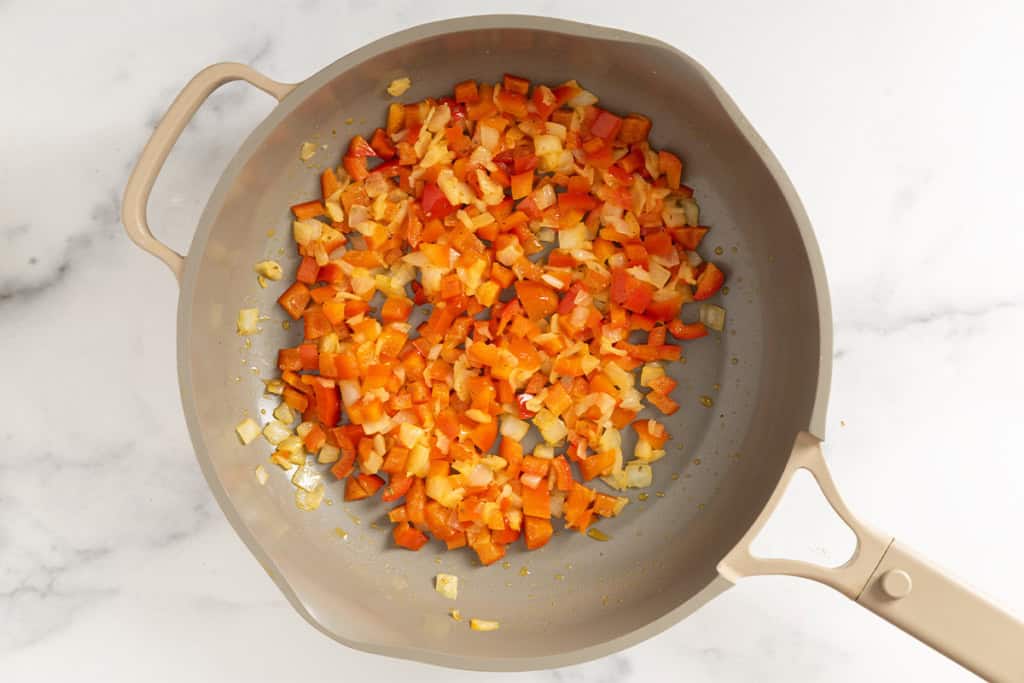 Peppers in skillet for veggie egg bake.