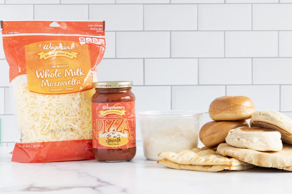 ingredients for mini pizzas on counter.