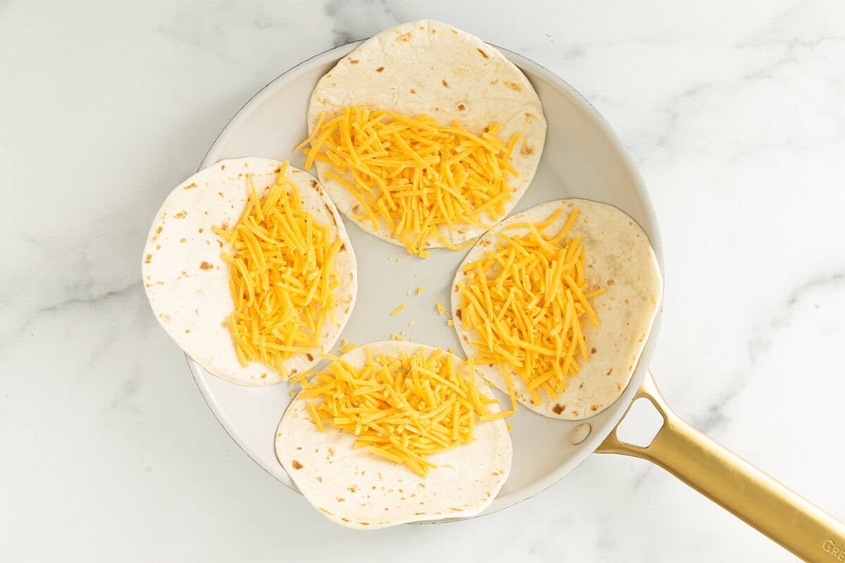 Making cheese quesadillas in pan.