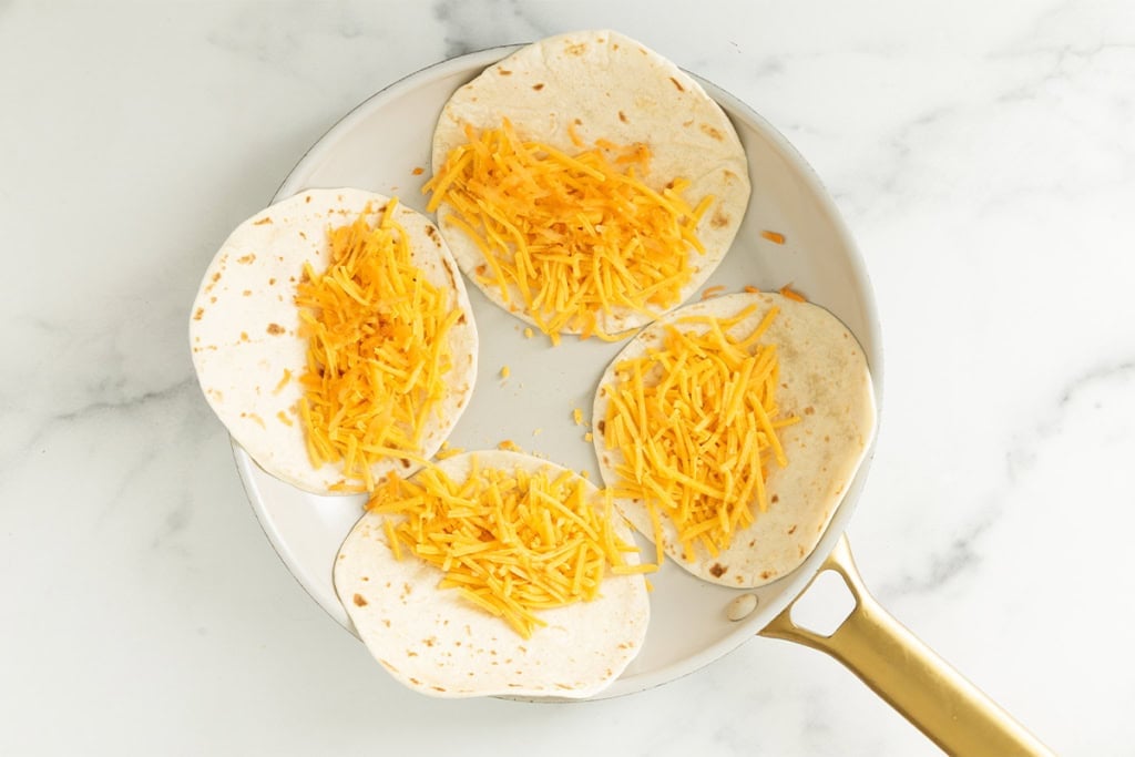 Making cheese quesadillas in pan.