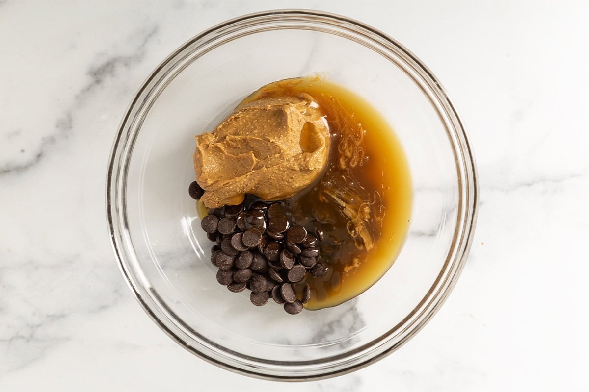 Ingredients for chocolate crunch bars in glass bowl before mixing.