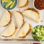 Mini tacos on baking sheet with sides.