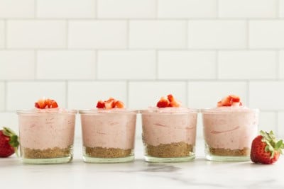 No bake strawberry cheesecakes in four glasses.