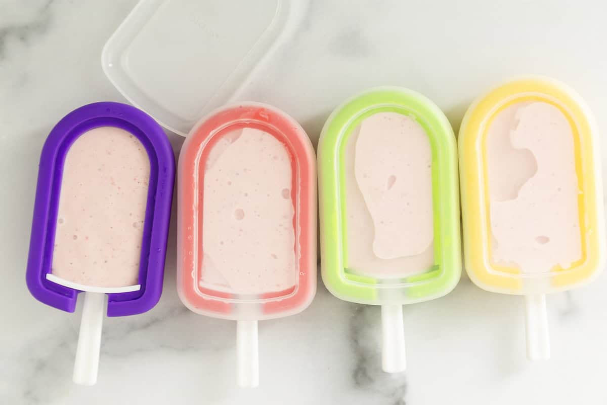 Strawberry ice cream bars in freezer containers.