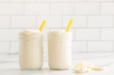 Banana shake in two glasses with straws.