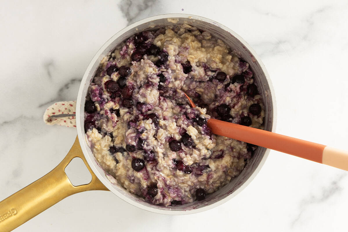 Blueberry oatmeal in pot with spoon.